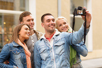 Image showing group of smiling friends making selfie outdoors