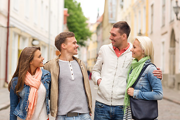 Image showing group of smiling friends walking in the city