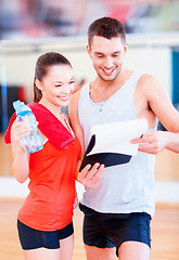 Image showing smiling male trainer with woman in the gym