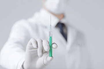 Image showing male doctor holding syringe with injection