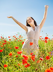 Image showing smiling young woman on poppy field