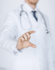 Image showing male doctor holding something in his hand