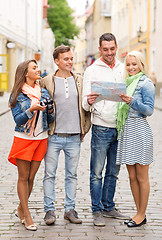 Image showing group of smiling friends with map and photocamera