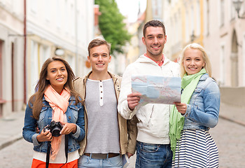 Image showing group of smiling friends with map and photocamera