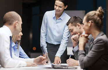 Image showing smiling female boss talking to business team