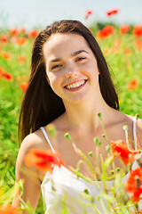 Image showing smiling young woman on poppy field