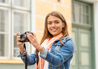 Image showing smiling girl with digiral photocamera in the city