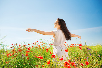 Image showing smiling young woman on poppy field