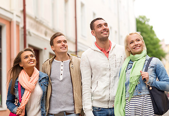 Image showing group of smiling friends walking in the city