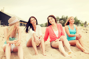 Image showing smiling girls with drinks on the beach