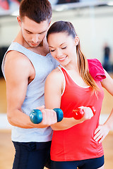 Image showing two smiling people working out with dumbbells