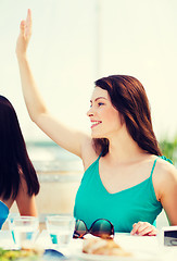 Image showing girl waving hand in cafe on the beach