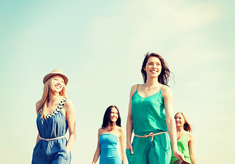 Image showing smiling girls walking on the beach