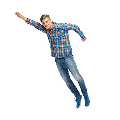 Image showing smiling young man flying in air