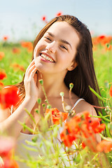 Image showing smiling young woman on poppy field