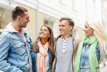 Image showing group of smiling friends walking in the city