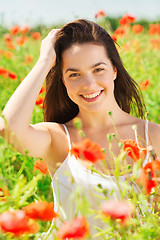 Image showing smiling young woman on poppy field