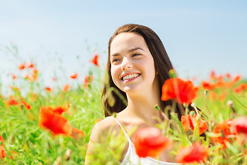 Image showing smiling young woman on poppy field