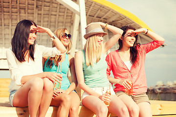 Image showing smiling girls with drinks on the beach