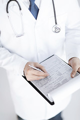 Image showing male doctor holding prescription paper in hand