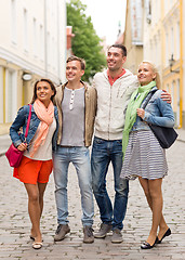 Image showing group of smiling friends walking in the city