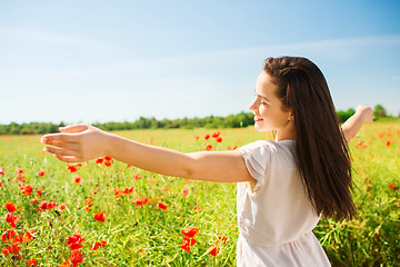 Image showing smiling young woman on poppy field