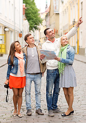 Image showing group of smiling friends with map and photocamera