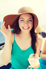 Image showing smiling girl in hat with champagne glass