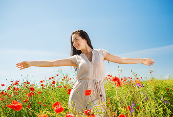 Image showing smiling young woman on poppy field