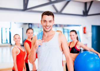 Image showing smiling man standing in front of the group in gym