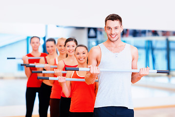 Image showing group of smiling people working out with barbells