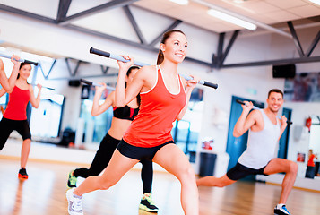 Image showing group of smiling people working out with barbells