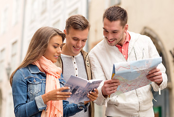 Image showing group of smiling friends with city guide and map