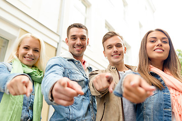 Image showing group of smiling friends in city pointing finger