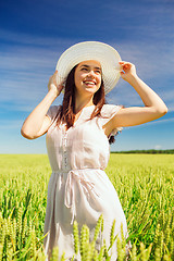 Image showing smiling young woman in straw hat on cereal field