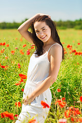 Image showing smiling young woman on poppy field