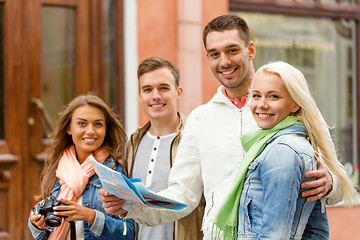 Image showing group of smiling friends with map and photocamera