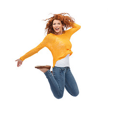 Image showing smiling young woman jumping in air