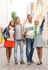 Image showing group of smiling friends with map and photocamera