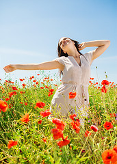 Image showing smiling young woman on poppy field