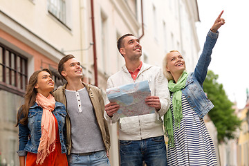 Image showing group of smiling friends with map exploring city