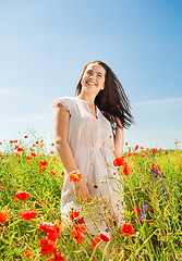 Image showing smiling young woman on poppy field