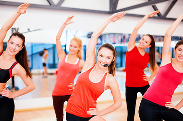 Image showing group of smiling people stretching in the gym