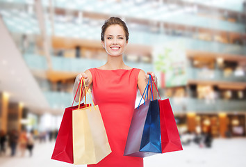 Image showing smiling elegant woman in dress with shopping bags