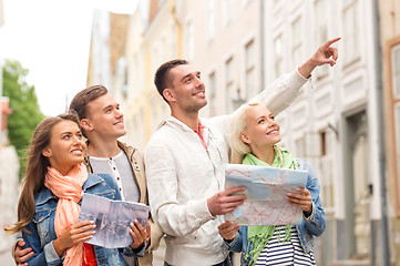 Image showing group of smiling friends with city guide and map