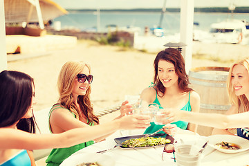 Image showing smiling girls looking at tablet pc in cafe