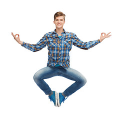 Image showing smiling young man flying in air