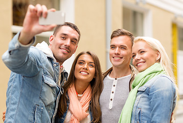 Image showing group of smiling friends making selfie outdoors