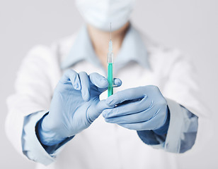 Image showing female doctor holding syringe with injection