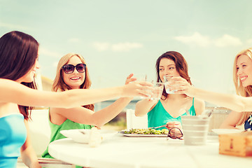 Image showing smiling girls looking at tablet pc in cafe